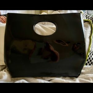 Black patent leather clutch bag can be worn open or folded w/handle or under arm